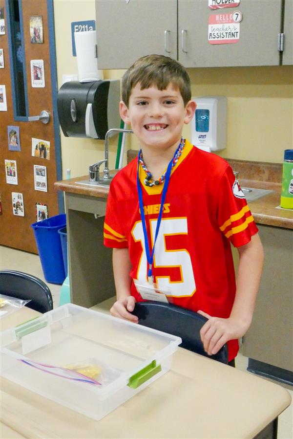 boy at desk in red shirt